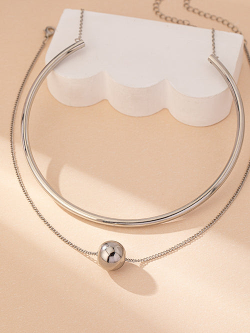 Een niche-ontwerpcombinatie van gestapelde halskettingen en halsbanden met ronde ballen